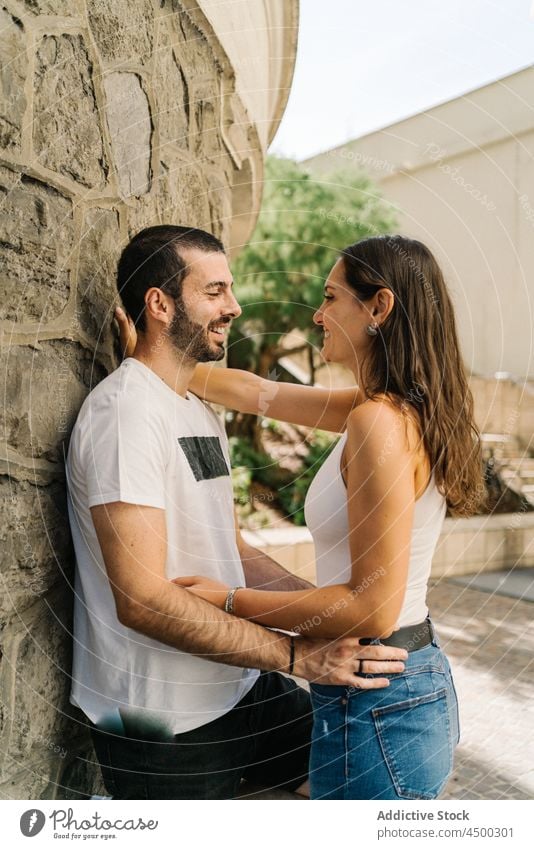 Verliebtes junges hispanisches Paar kuschelt in der Nähe einer alten Steinmauer in der Stadt Umarmen Lächeln Termin & Datum Liebe romantisch Partnerschaft