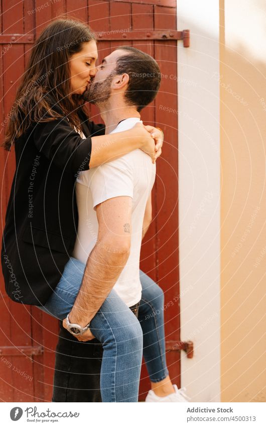 Junger ethnischer Mann umarmt und küsst Freundin mit geschlossenen Augen Paar Kuss Umarmung Liebe Glück Augen geschlossen Partnerschaft Zusammensein Umarmen