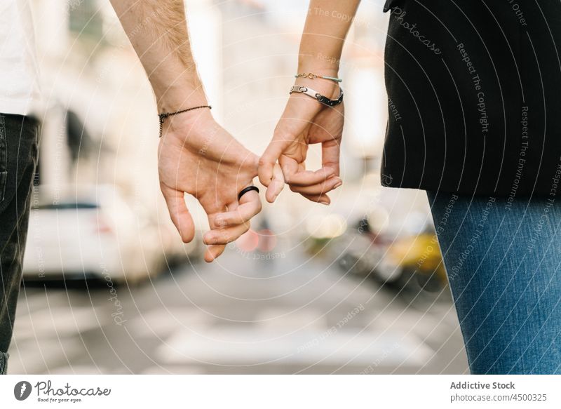 Anonymes Paar hält kleine Finger, während es auf der Straße spazieren geht Spaziergang Händchenhalten Partnerschaft Liebe Zusammensein Großstadt romantisch