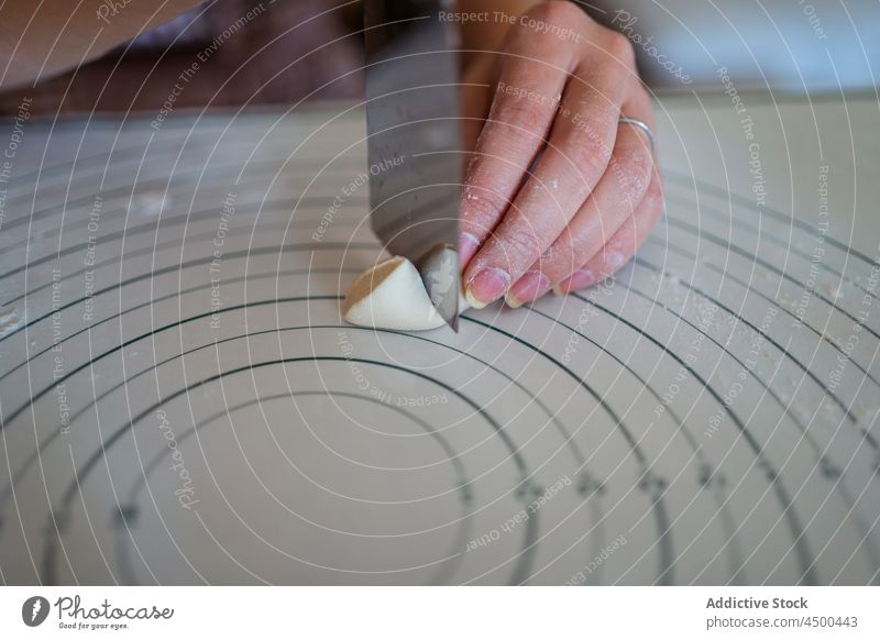 Unbekannte Frau schneidet Teig in der Küche und bereitet Knödel zu geschnitten Teigwaren vorbereiten roh selbstgemacht kulinarisch Messer Koch Prozess heimwärts
