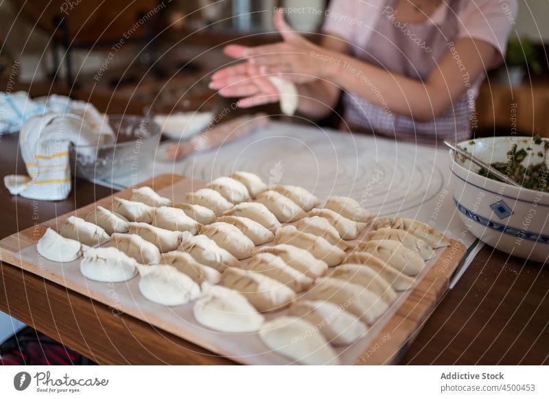 Crop Hausfrau rollt Teig mit den Händen Frau asiatisch Chinesisch rollen Teigwaren Koch Küche Knödel selbstgemacht vorbereiten Lebensmittel Prozess Rezept