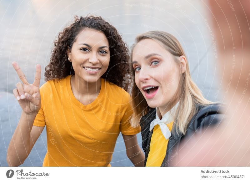 Fröhlich junge multirassische Frauen lächelnd und unter selfie auf der Straße Selfie Lächeln zwei Finger Freund Zusammensein Zeit verbringen Glück gestikulieren