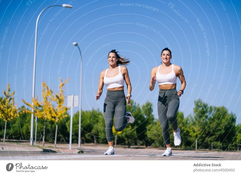 Inhalt Zwillingsschwestern joggen auf Asphalt Frauen laufen passen Fitness Schwester Aktivität sportlich Zusammensein Lifestyle schlank Geschwisterkind