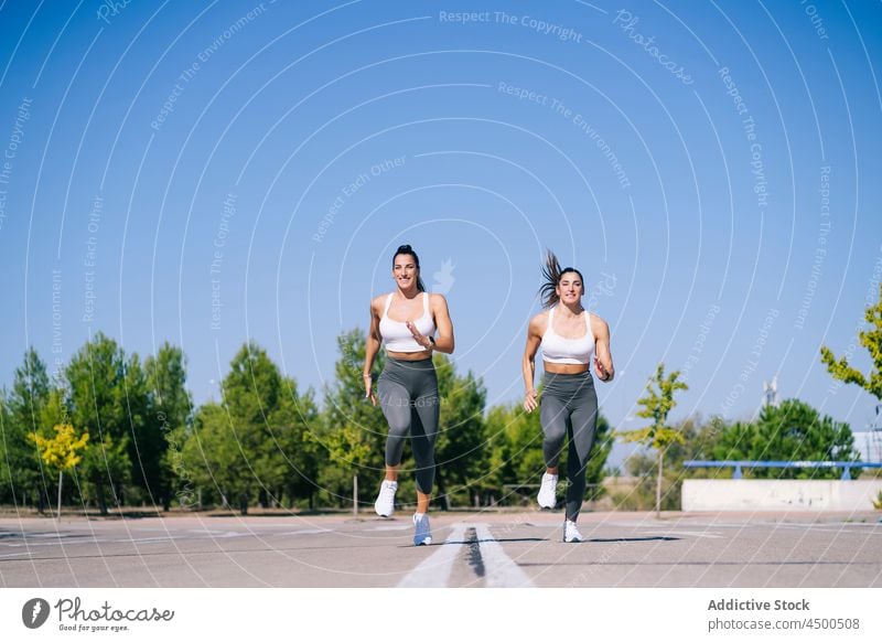 Inhalt Zwillingsschwestern joggen auf Asphalt Frauen laufen passen Fitness Schwester Aktivität sportlich Zusammensein Lifestyle schlank Geschwisterkind