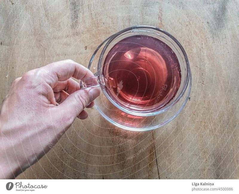 die Hand nimmt den roten Tee in der Tasse auf Getränk Gesundheit Farbfoto Kräutertee Studioaufnahme Design Stil Kräuter & Gewürze Gesunde Ernährung