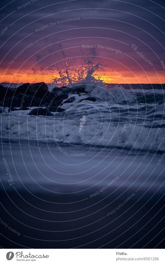 Welle bricht an Steinen vor der untergehenden Sonne Nordsee Küste Ozean Meer Nordseeküste Tropfen Strand Ferien & Urlaub & Reisen Wasser Sand Natur Himmel