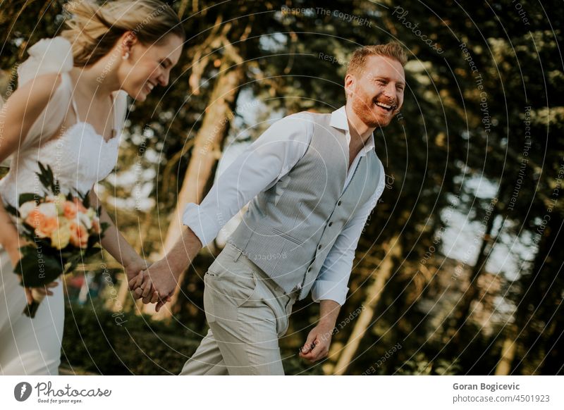 Junges, frisch verheiratetes Paar beim Spaziergang im Park schön Schönheit Braut Kaukasier heiter Kontakt Tag Kleid Umarmen Emotion Familie Gefühle Frau Ingwer