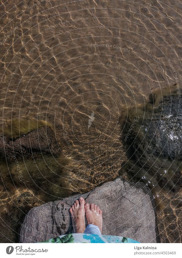Blick von oben auf nackte Füße auf Stein neben dem Wasser am Meer MEER Ostsee Ferien & Urlaub & Reisen Ostseeküste Strandkorb Himmel Tourismus Erholung Küste