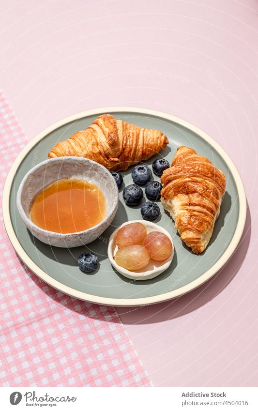 Teller mit leckeren Croissants mit Blaubeeren und Marmelade auf dem Tisch Frühstück frisch dienen geschmackvoll Lebensmittel Dessert süß Gebäck Beeren gebacken