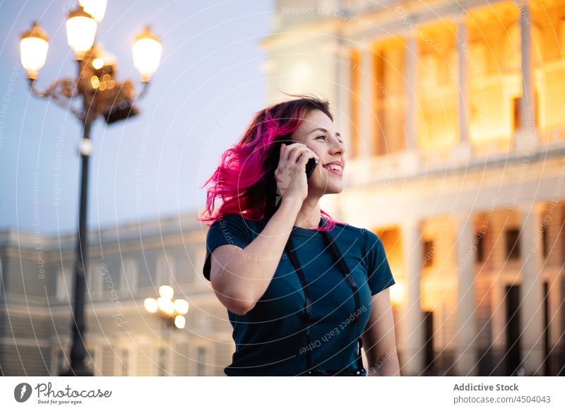 Positive Frau telefoniert in der Nähe eines historischen Gebäudes Smartphone Straße gealtert klassisch Internet online rosa Haare Stil Funktelefon Mobile