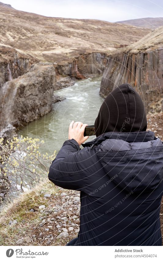 Reisende, die die malerische Landschaft der Schlucht bei Tageslicht fotografieren Person reisen Smartphone Apparatur Klippe Natur Fluss Reisender Island