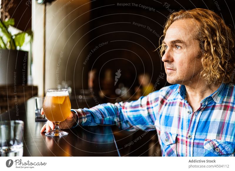 Nachdenklicher Mann trinkt Bier in einer Bar bei Tageslicht Alkohol trinken nachdenklich Getränk besinnlich Pub sitzen männlich lässig Glas Windstille