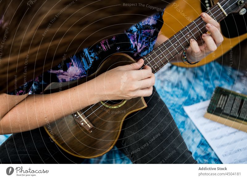 Anonyme Musikerin spielt Ukulele am Meeresstrand bei Tageslicht Frau spielen Instrument Gesang Talent Strand singen Hobby Natur Melodie ausführen Sand genießen