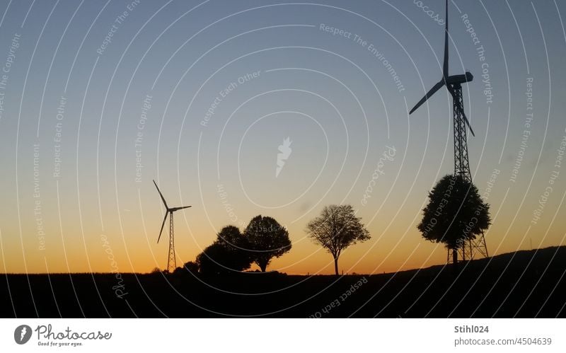 Windkraftanlage auf Gittermast im Abendrot Windrad Windenergie Energieversorger Strom Stromerzeuger FArbverlauf Dämmerung Horizont Silhouette Scherenschnitt