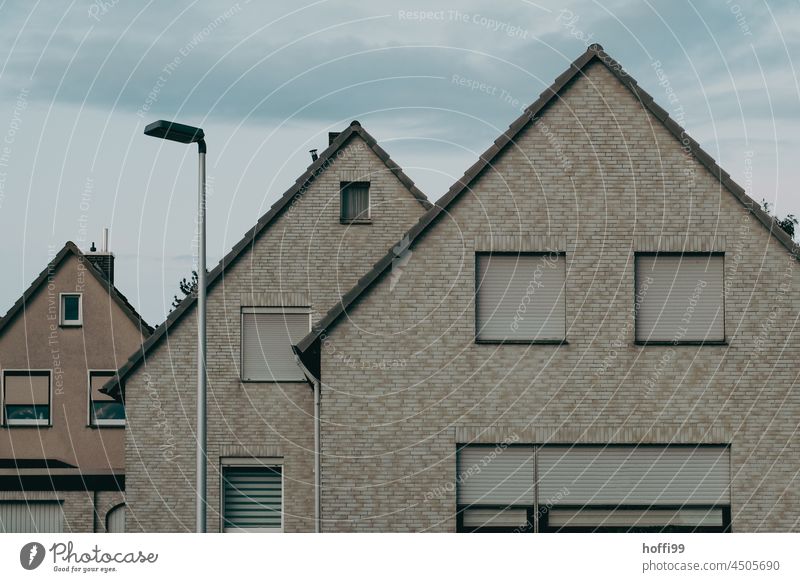 Tristesse von geschlossene Rollläden auf grauen Fassaden in einer Kleinstadt Depression deprimiert Rollladen trist Fenster Gebäude Mauer Jalousie