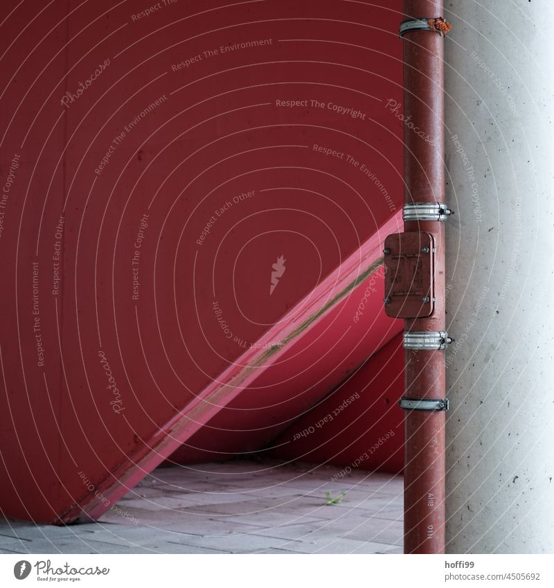 rotes Fallrohr mit Sichtbeton Sichtbetonwand abstrakt minimalistisch Fassade grau Linie Mauer trist modern Bauwerk Strukturen & Formen Beton Minimalismus Muster