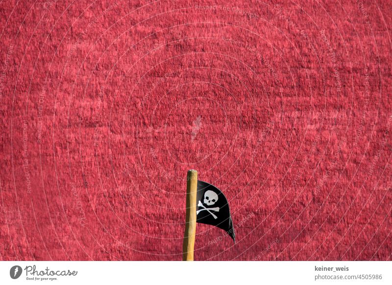 Jolly Roger oder die Piratenflagge vor rotem Hintergrund im Irgendwo und Sowieso mit viel Textfreiraum Fahne Piratenfahne Totenkopfflagge Totenkopffahne
