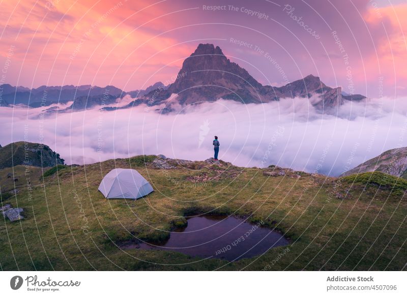 Unbekannter Reisender auf grasbewachsenem Feld mit Zelt auf einem Berg über den Wolken Tourist Berge u. Gebirge Klippe Abenteuer Natur Wanderer Nebel reisen
