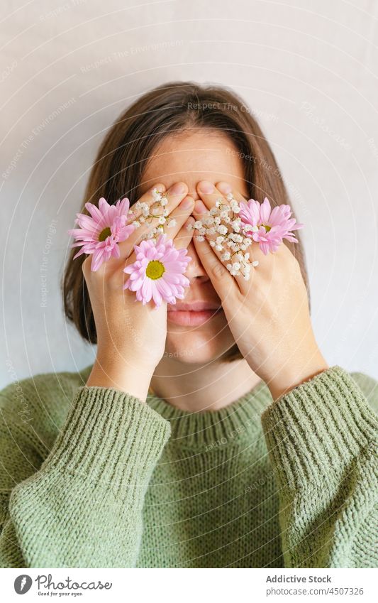 Frau bedeckt Gesicht mit blühenden Blumen Blütezeit Blütenknospen Chrysantheme Gypsophila Tierhaut filigran geheim schüchtern Angebot sanft Porträt Pflanze