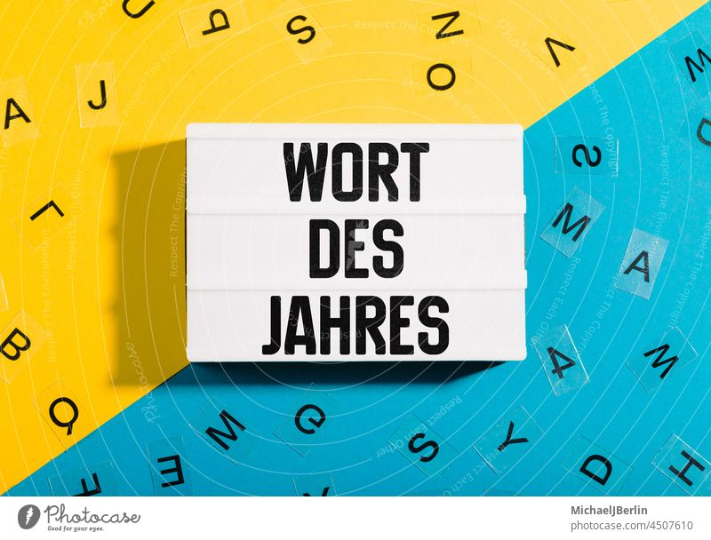 Sprach Symbolbild zu Wort des Jahres mit gelb blauem Papier Untergrund als Titel für deutsche Grammatik und Sprache wort jahr leuchtkasten leuchtbox lichtbox