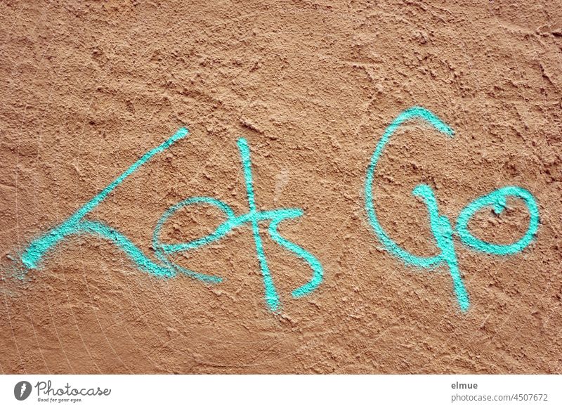 Lets Go ist in türkis an die verputzte Wand gesprayt lets go Graffito sprayen englisch Jugendhilfe loslassen auf gehts losgelassen entlassen Botschaft