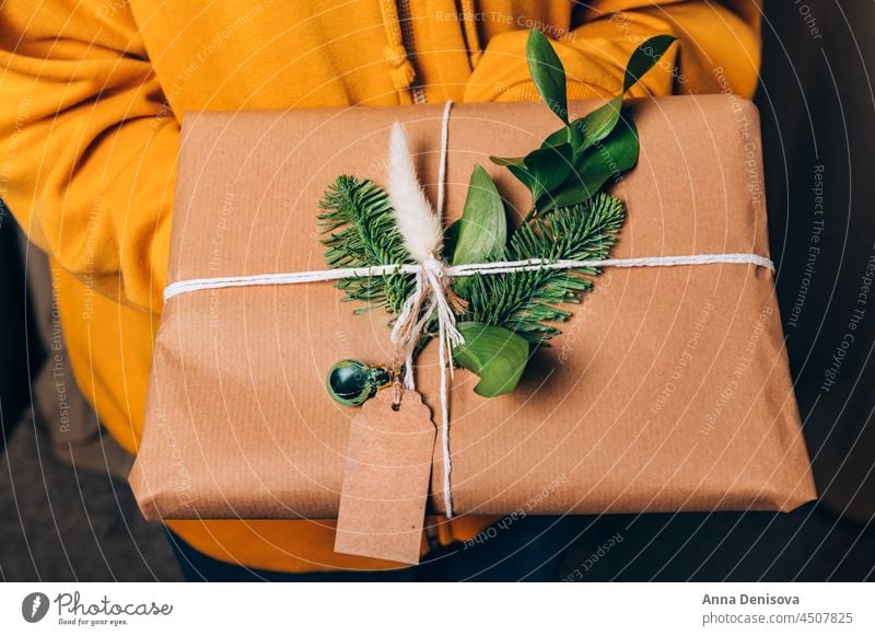 Hände halten Geschenk in Öko-Papier Verpackung Weihnachten Neujahr Feiertag Kasten recyceltes Kraftpapier präsentieren Überraschung handgefertigt kreativ