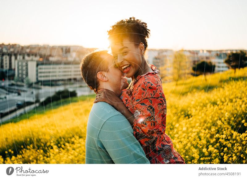 Romantische liebevolle verschiedene Paar küssen in der Natur am sonnigen Tag Umarmen Kuss Liebe romantisch Termin & Datum Lächeln Zusammensein Umarmung