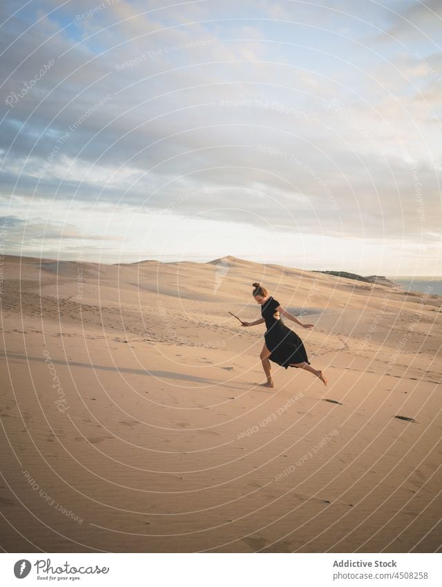 Frau im Kleid läuft auf sandigen Dünen wüst Sand trocken heiß Harmonie elegant exotisch Freiheit Gelassenheit Umwelt Barfuß Hügel erkunden erwärmen Sonnenlicht