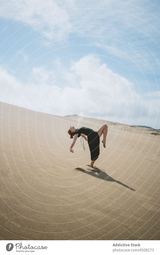 Anmutige Frau tanzt in sandiger Wüste Tänzer Tanzen Düne wüst sich[Akk] bewegen Körperhaltung beweglich Sand Bein angehoben Bewegung Dehnung ausführen Freiheit