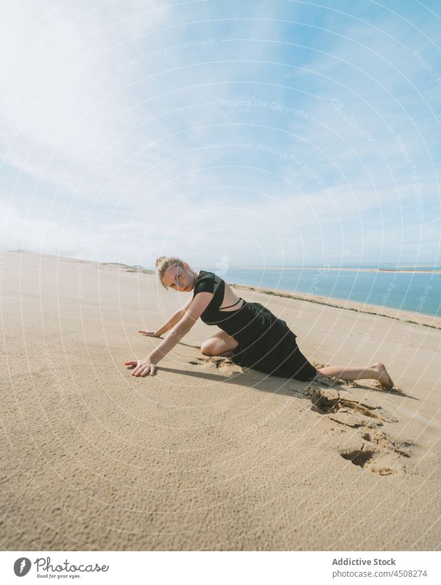 Anmutige Frau in sandiger Wüste liegend Düne wüst sich[Akk] bewegen Körperhaltung beweglich Sand Bewegung Dehnung ausführen Freiheit Balletttänzer Barfuß
