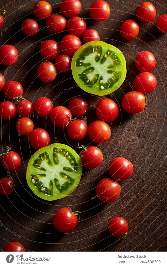 Unreife und rote Kirschtomaten auf brauner Oberfläche Tomate Streuung Scheibe Gemüse unreif Ernte Vitamin viele Landschaft Ackerbau Agronomie Garten Bauernhof