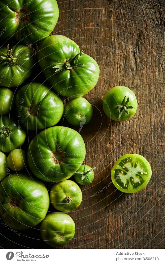 Tomate auf einem Holztisch in der Nähe von unreifen Tomaten in Scheiben schneiden Kirschtomate Streuung Gemüse Ernte Vitamin viele Landschaft Ackerbau Agronomie