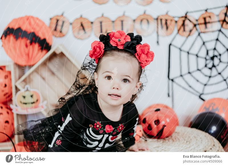 schönes einjähriges kaukasisches Mädchen in Halloween-Kostüm zu Hause mit Halloween-Dekoration, Lifestyle drinnen. Halloween-Party-Konzept. Tracht