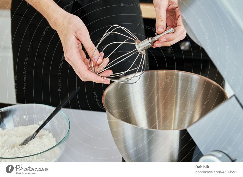 Frau setzt die Schneebesen-Düse eines elektrischen Mixers ein Küche Schalen & Schüsseln Geräte Mischen Lebensmittel Hintergrund Bäckerei Mischer Kaukasier Koch
