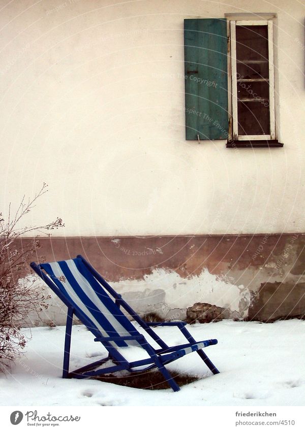 Liegestuhl im Schnee I Fenster Tag Winter Fensterladen Haus Wand blau Streifen Tauwetter Wetter Stimmung Schneelandschaft Garten Park