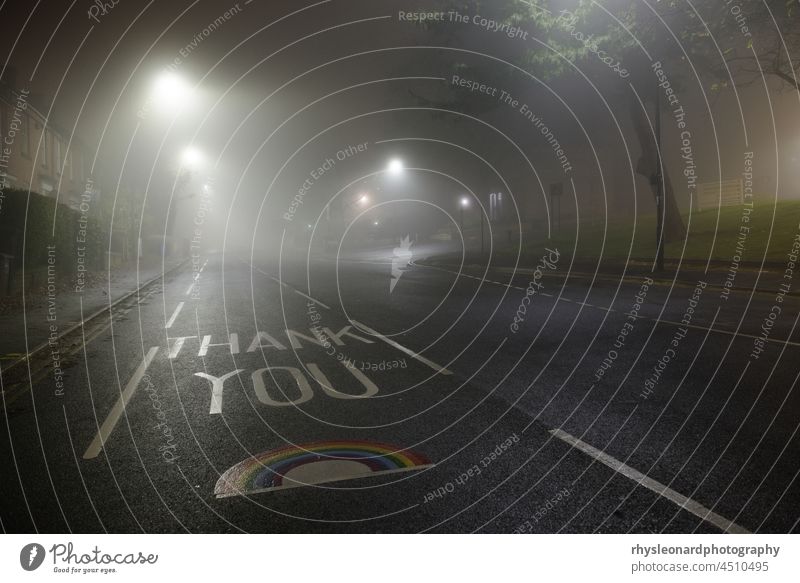 Dankeschön NHS Regenbogen auf der Glossop Road, Hallamshire Krankenhaus gemalt. Sehr neblige Nachtszene, beleuchtet von Straßenlampen. Leere Straße ohne Autos.