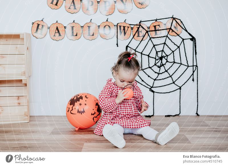 schönes einjähriges kaukasisches Mädchen zu Hause mit Halloween-Dekoration, Lifestyle drinnen. Halloween-Party-Konzept. Tracht im Innenbereich Glück Atelier