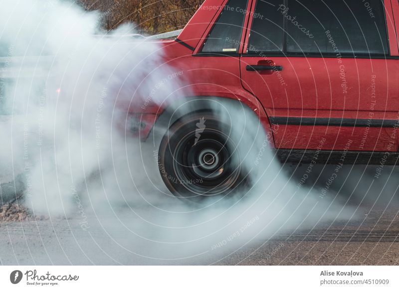 die Reifen verbrennen PKW Burnout rotes Auto Reifenverbrennung Reifen in Bewegung Farbfoto Gummi Bewegung eines Reifens brennend Rad Autoreifen fahren Fahrzeug
