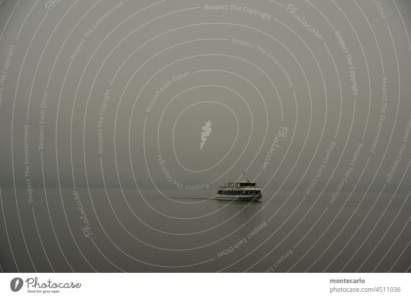 Ein Passagierschiff alleine auf dem tristen Bodensee November touristisch schlechte Sicht nebelig Herbst Nebel grau in grau See Wasser Diesig Saisonende