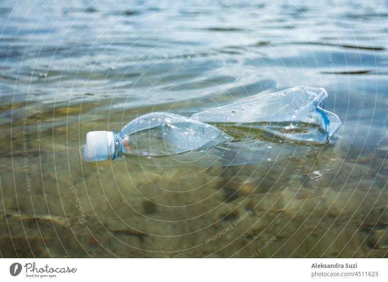 Eine gebrauchte Plastikflasche schwimmt in klarem Wasser. Globales Umweltproblem der Plastikverschmutzung auf dem Planeten. Plastikmüll im Meer. Hintergrund