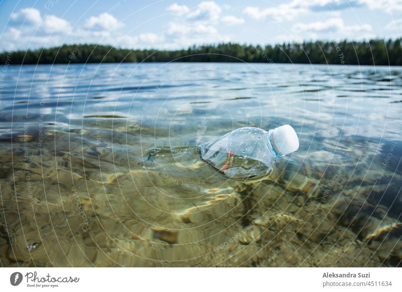 Eine gebrauchte Plastikflasche schwimmt in klarem Wasser. Globales Umweltproblem der Plastikverschmutzung auf dem Planeten. Plastikmüll im Meer. Hintergrund