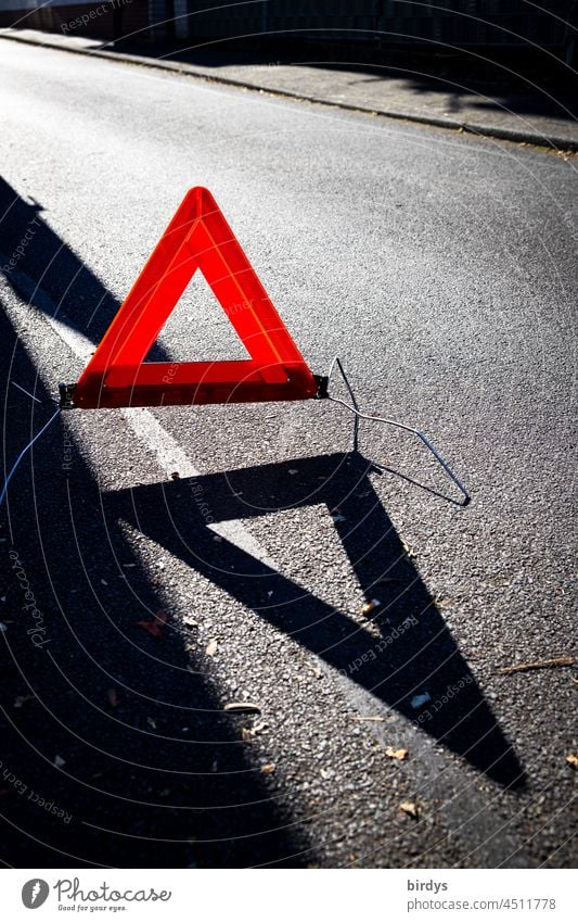 Rotes Warndreieck im Gegenlicht mit Schattenwurf auf einer Straße - ein  lizenzfreies Stock Foto von Photocase