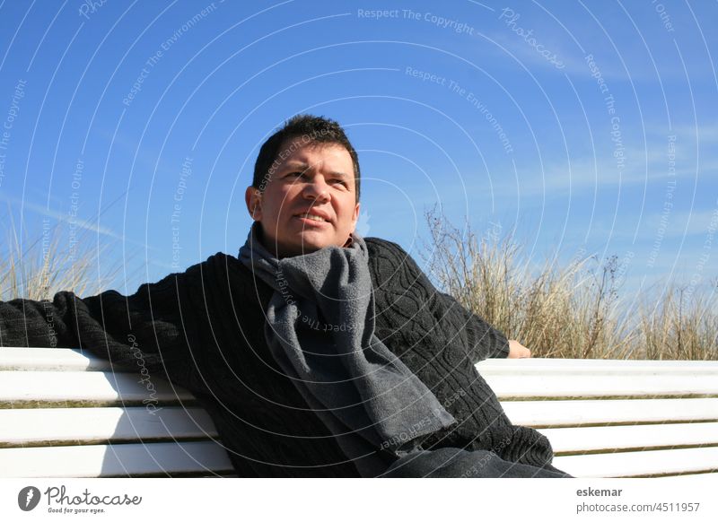 Mann auf Parkbank im Winter Bank fünfzig 50 selbstbewußt lächeln Überheblichkeit selbstsicher Ich-Stärke Selbstbewußtsein winterlich Generation plus sitzen