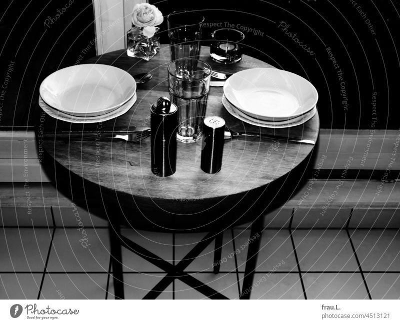 Abendessen für zwei Holztisch Löffel Gabel Messer Vase Salzstreuer Pfeffermühle Gläser Wasserglas Glas Rose Tisch Teller Besteck Essen Teelicht Fenster