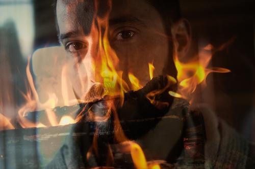 Doppelbelichtung: Männergesicht im Feuer Mann Gesicht Doppelbeichtung brennen Brand Flamme bärtig männlich verbrennen Wärme Blick Blick in die Kamera