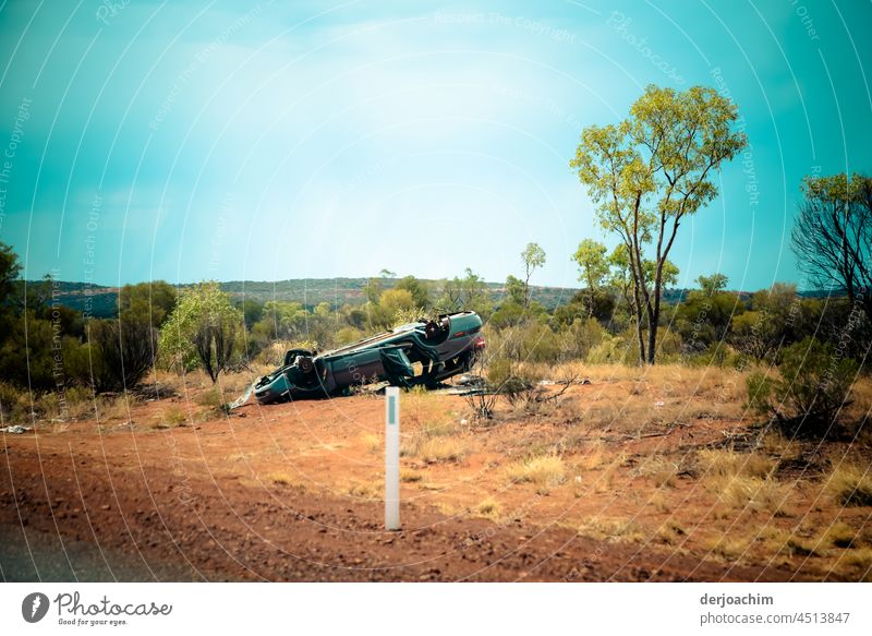 Schwerer Unfall im Outback. Der Pkw liegt zertrümmert auf dem Dach am Straßenrand. kaputt Menschenleer Farbfoto Außenaufnahme Tag Schaden Zerstörung PKW Verkehr