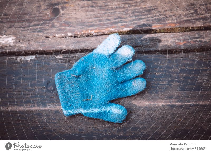 Handschuh auf einer Bank Handschuhe einzeln blau Menschenleer Außenaufnahme Farbfoto braun Licht Schatten Holzbrett Maserung Kontrast Strukturen & Formen
