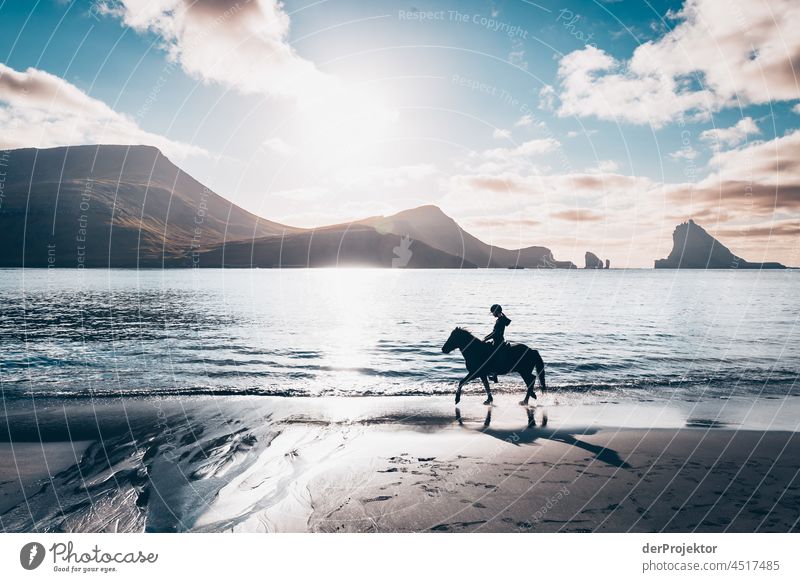Strand mit Reiterin mit Aussicht auf den Färöer Inseln Gásadalur Brandung schroff Berghang Gelände Sonne abweisend kalte jahreszeit Dänemark Naturerlebnis