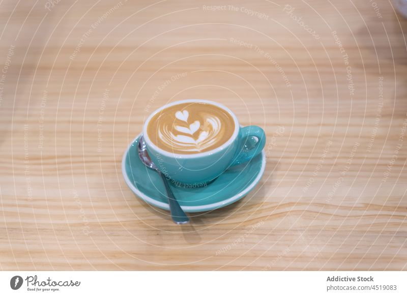 Tasse Milchkaffee auf Teller Kaffee Latte Latte Art dienen Café Koffein Heißgetränk Getränk schäumen trinken Kaffeelöffel Aroma Kantine lecker frisch hölzern