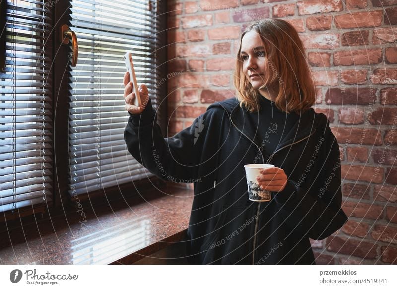 Junge Frau, die einen Videoanruf führt, aus der Ferne spricht und ein Selfie-Foto macht Smartphone Anruf unter benutzend Bild Mobile Telefon Pause Kaffee Person